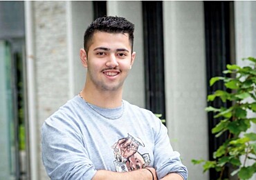 Jamil Mostafa posiert vor einem Gebäude.