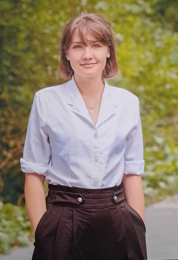 Natalia postet vor einem Hügel